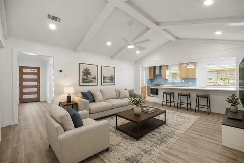 a living room with furniture and a wooden floor