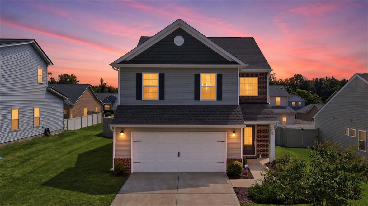 208 Grassy Creek Way Pendleton, SC 29670 - Photo 42 of 43 A classic facade with a welcoming porch and attached garage awaits at sunset.