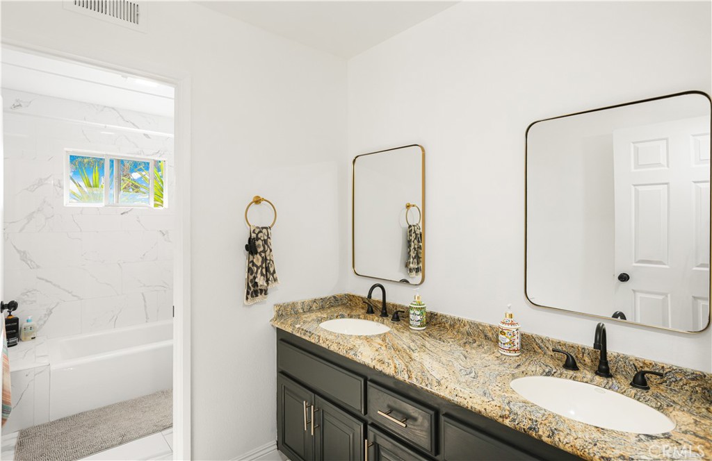 33532 Valle Road San Juan Capistrano, CA 92675 - Photo 50 of 60 a bathroom with a granite countertop sink and a mirror