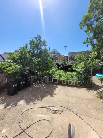a view of a garden with potted plants and large trees