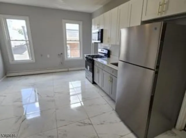 a kitchen with stainless steel appliances a refrigerator sink and cabinets