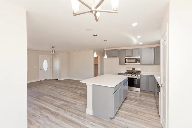 a large kitchen with kitchen island a sink dishwasher stove with wooden floor