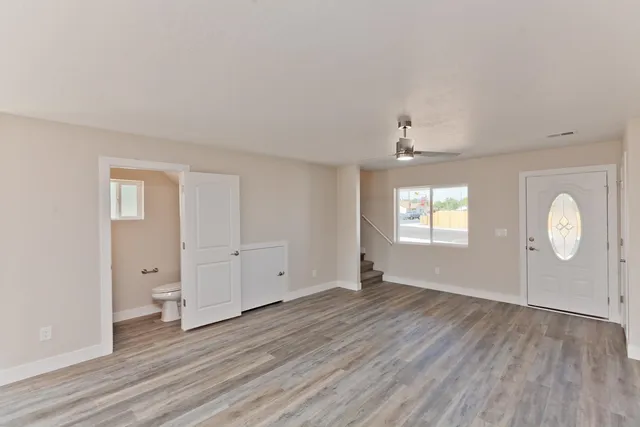 an empty room with wooden floor and windows
