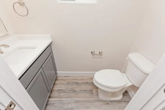 a white toilet sitting next to a bathroom sink and vanity