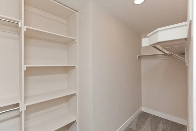 a view of walk in closet with empty racks