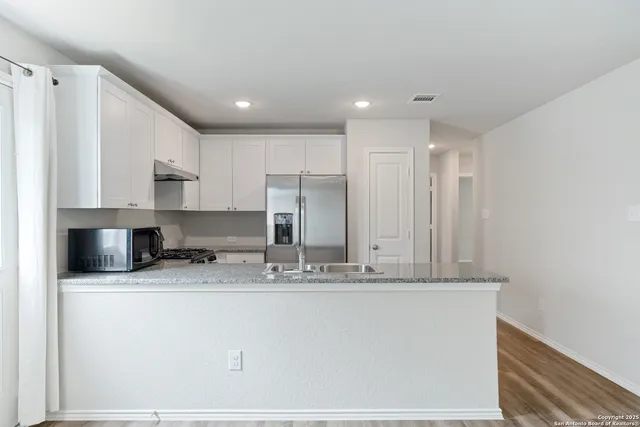 a view of a kitchen with granite countertop cabinets