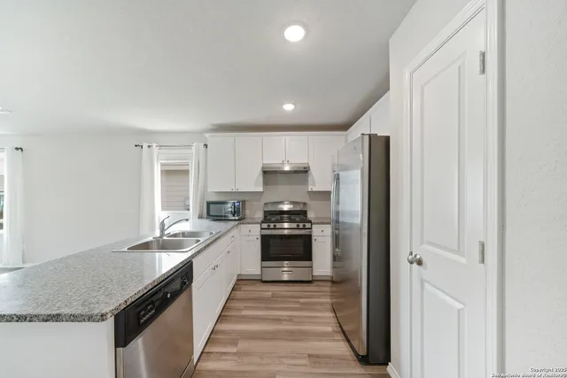 a kitchen with stainless steel appliances granite countertop a refrigerator and a sink