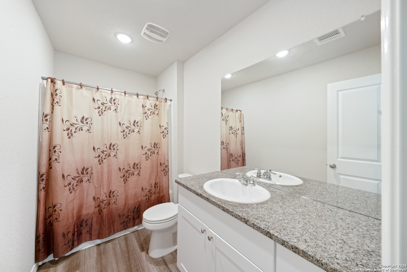6534 Augustus Magee San Antonio, TX 78220 - Photo 18 of 25 a bathroom with a granite countertop sink toilet and shower