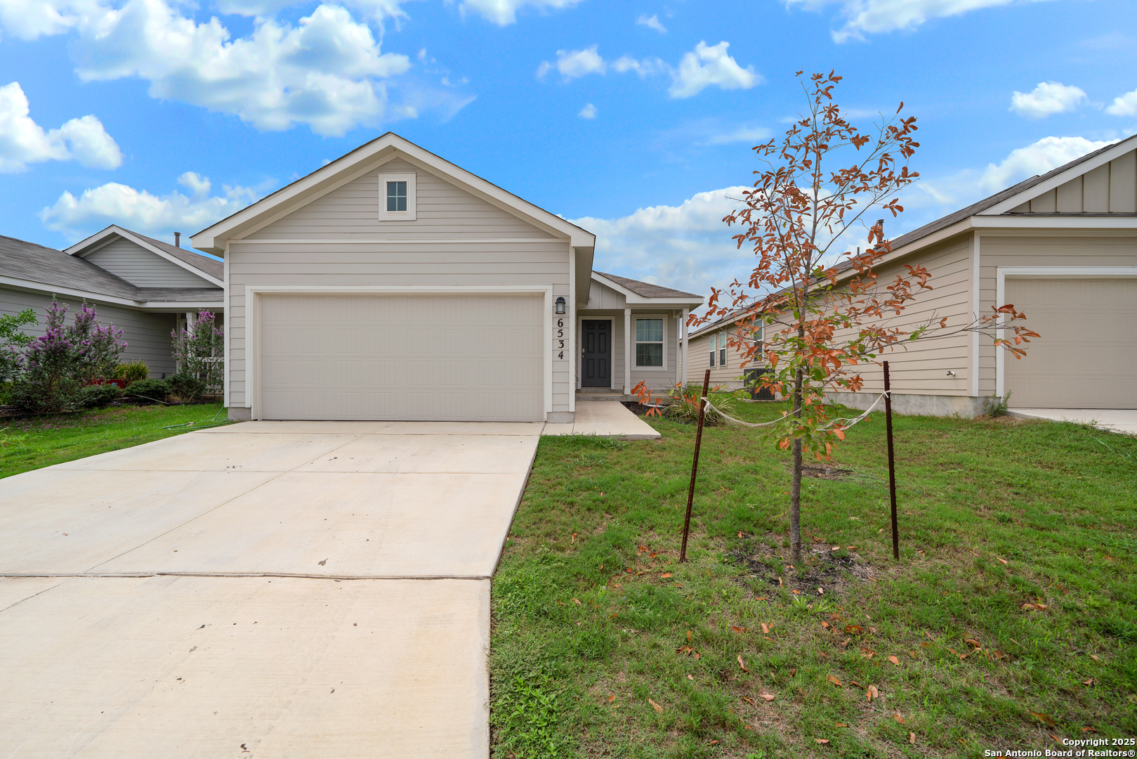 6534 Augustus Magee San Antonio, TX 78220 - Photo 2 of 25 a front view of a house with a yard and garage