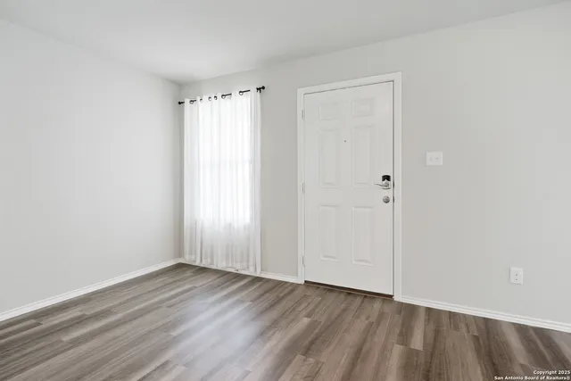a view of an empty room with wooden floor