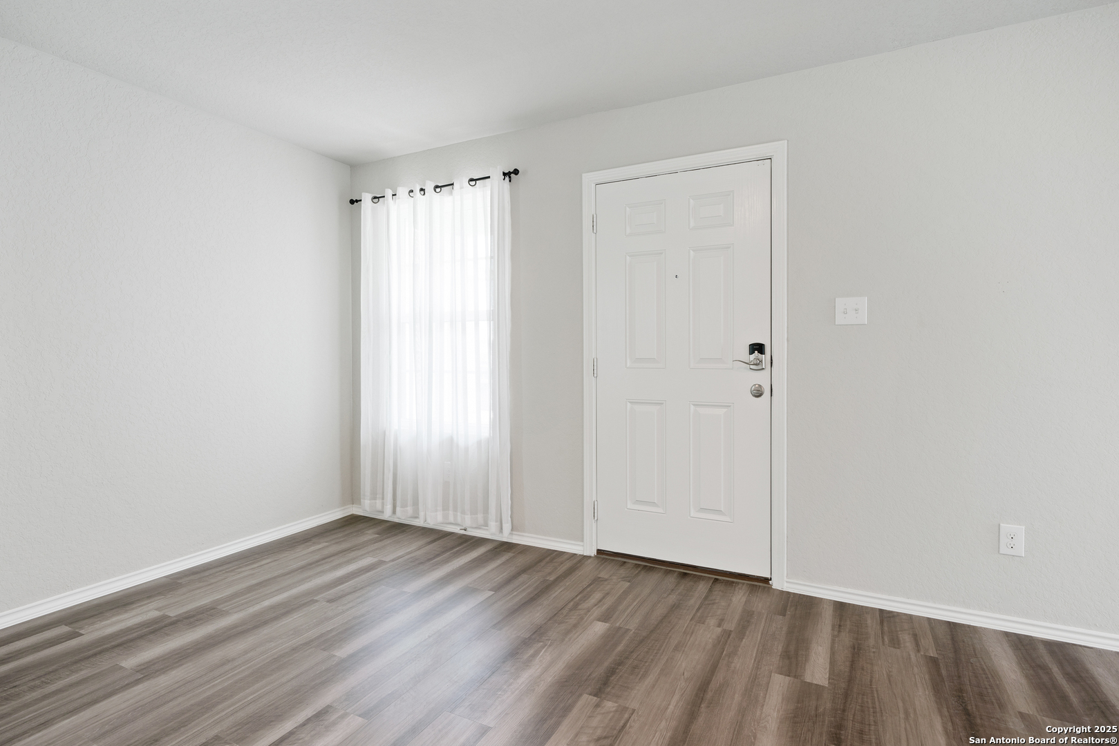 6534 Augustus Magee San Antonio, TX 78220 - Photo 5 of 25 a view of an empty room with wooden floor
