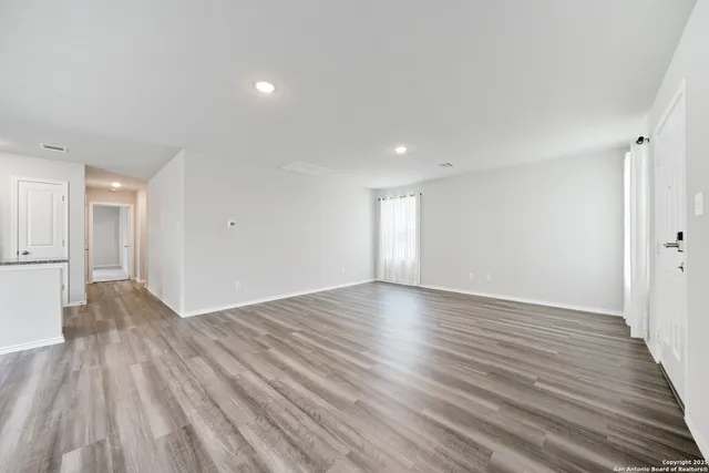 a view of empty room with wooden floor