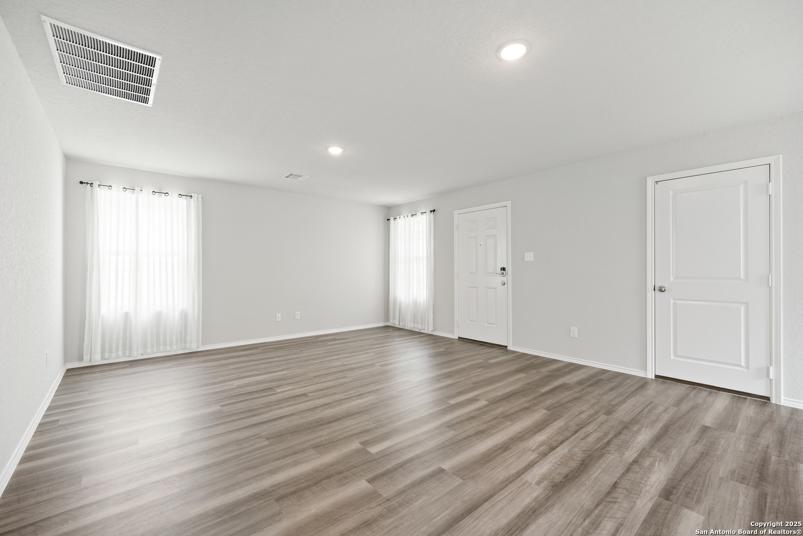 6534 Augustus Magee San Antonio, TX 78220 - Photo 9 of 25 a view of an empty room with wooden floor and a window