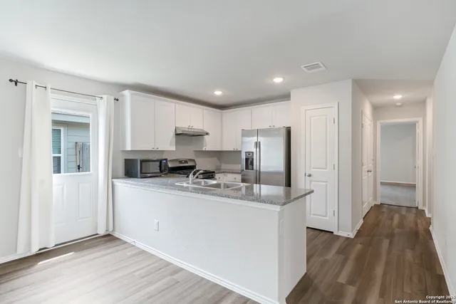 a kitchen with stainless steel appliances granite countertop a refrigerator sink and cabinets