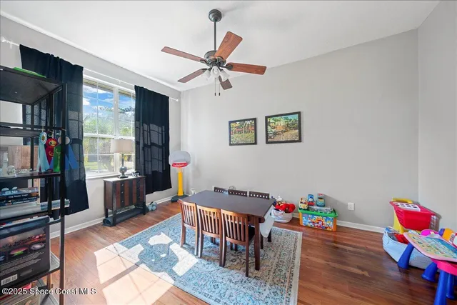 a living room with furniture a flat screen tv and a dining table