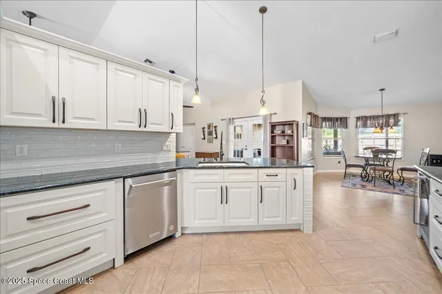 a kitchen with white cabinets and appliances