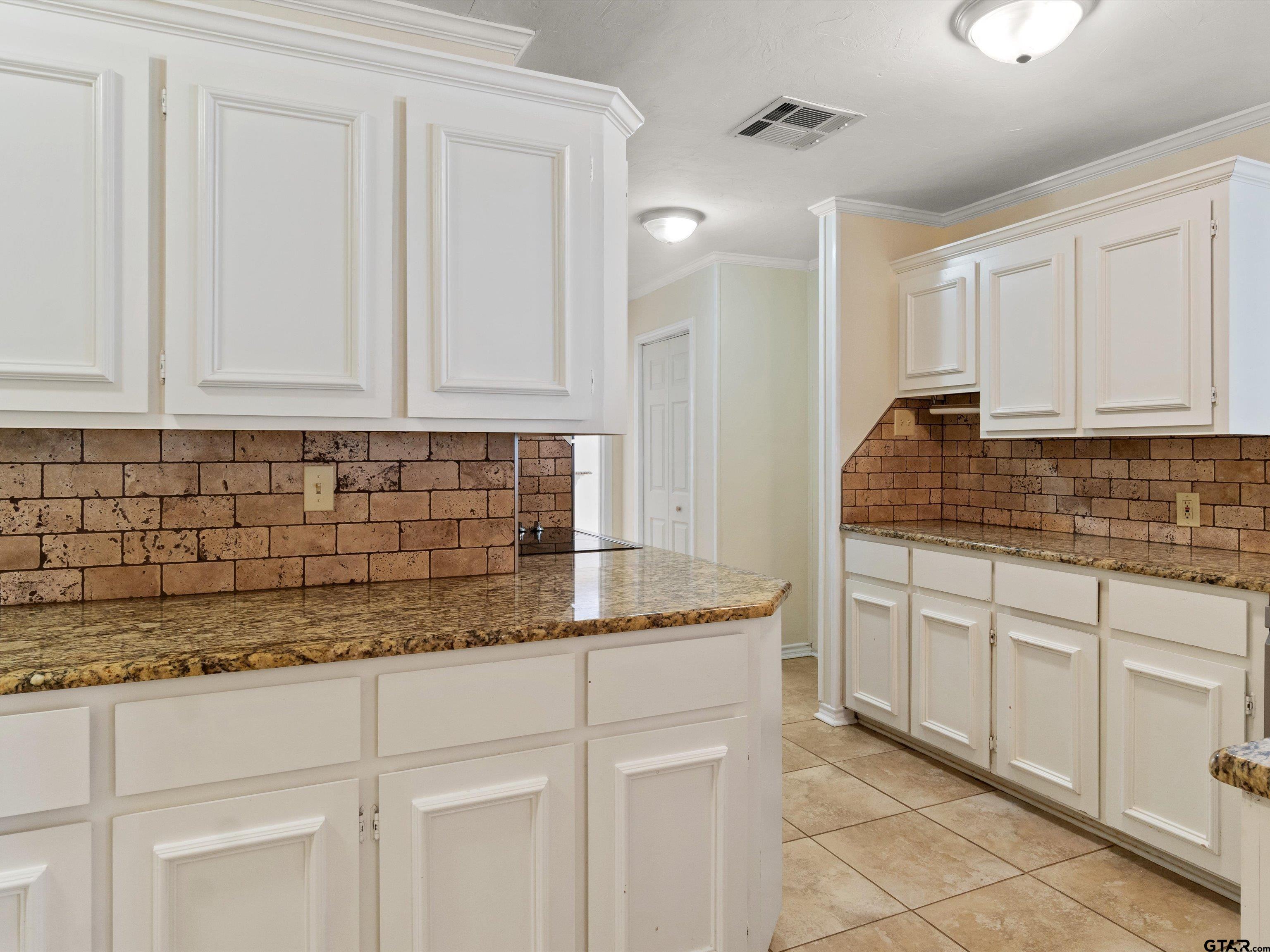 442 Golf Road Gilmer, TX 75645 - Photo 17 of 35 a kitchen with granite countertop white cabinets and sink