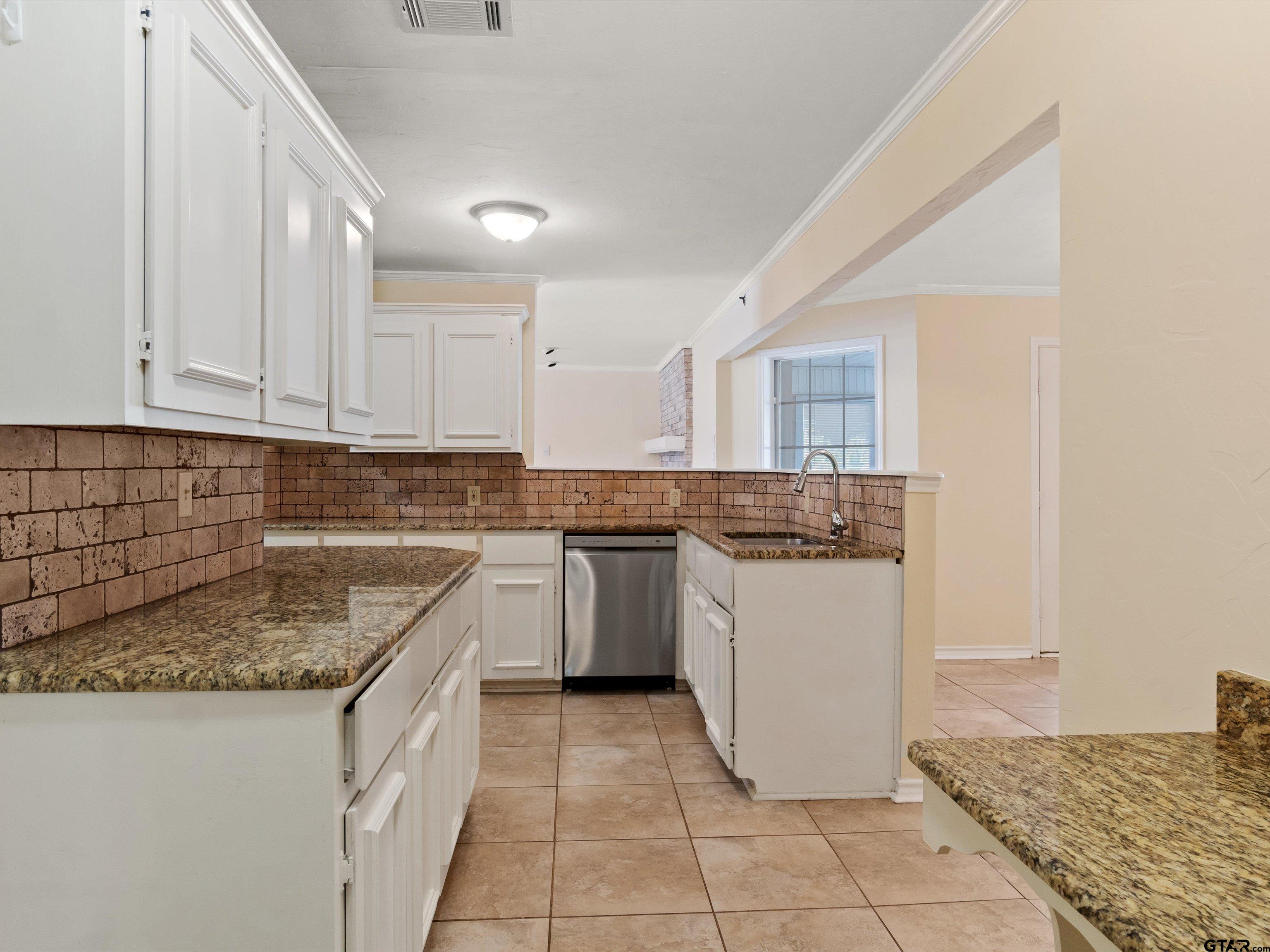 442 Golf Road Gilmer, TX 75645 - Photo 19 of 35 a kitchen with a sink a stove top oven and white kitchen