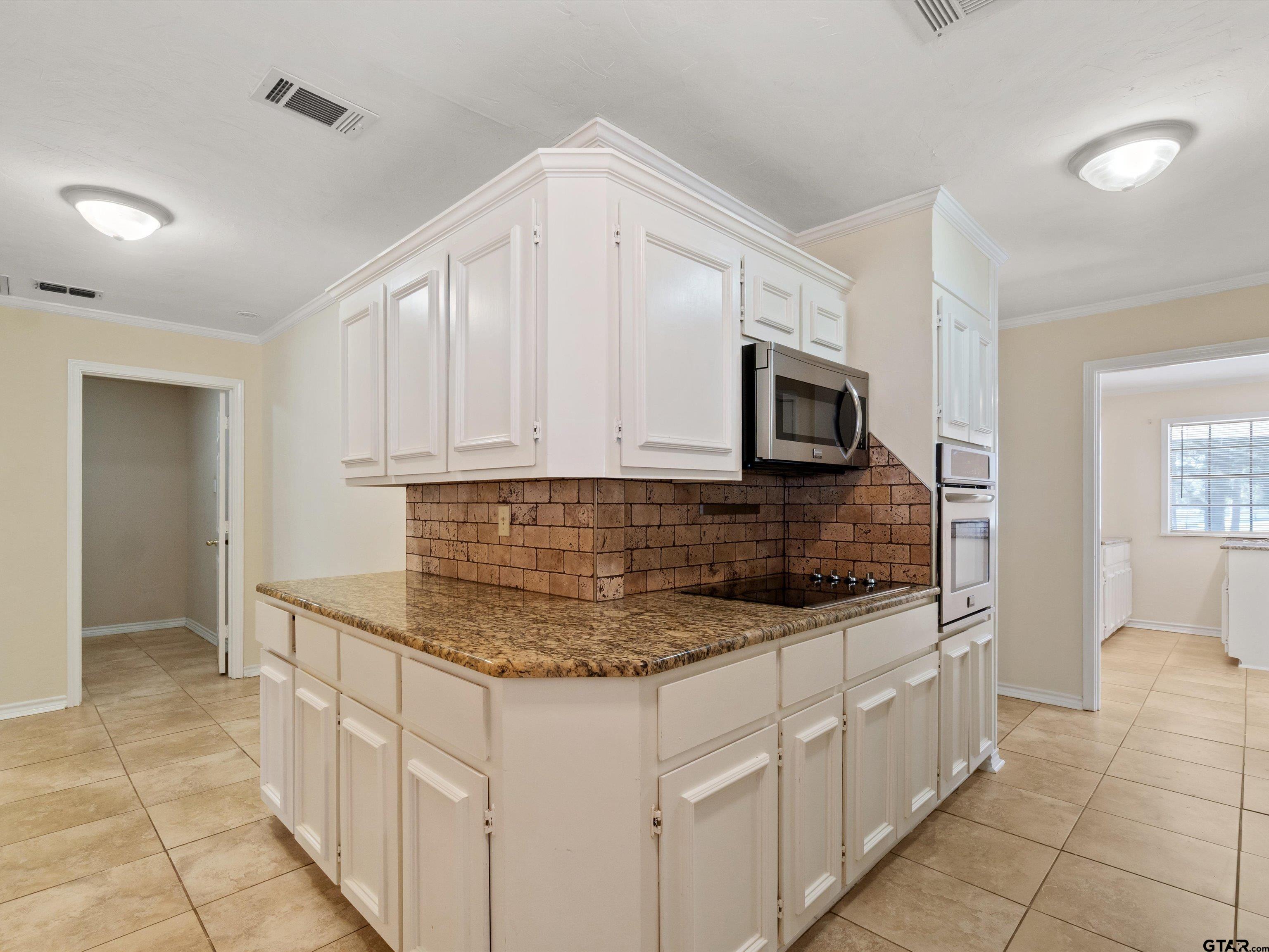442 Golf Road Gilmer, TX 75645 - Photo 20 of 35 a kitchen with stainless steel appliances granite countertop a sink and a microwave