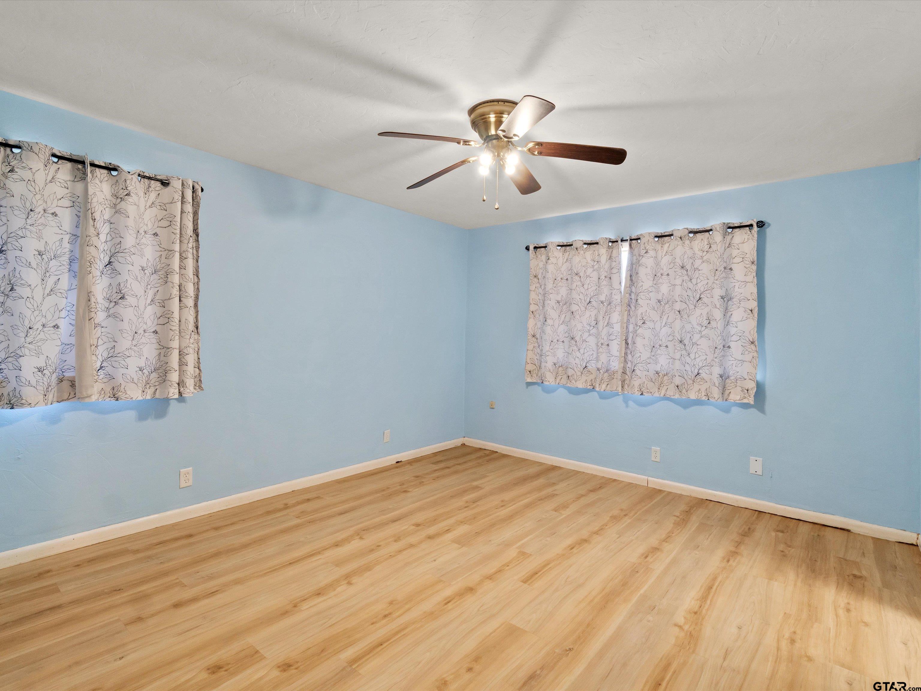 442 Golf Road Gilmer, TX 75645 - Photo 30 of 35 a view of an empty room with window and wooden floor
