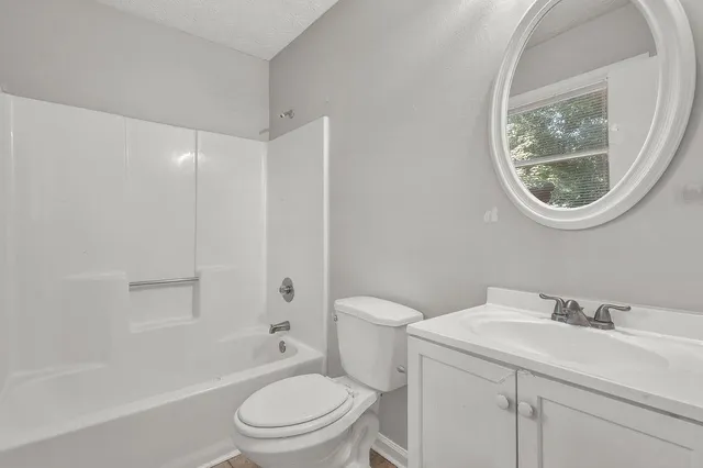 a white toilet sitting next to a bathroom sink and tub