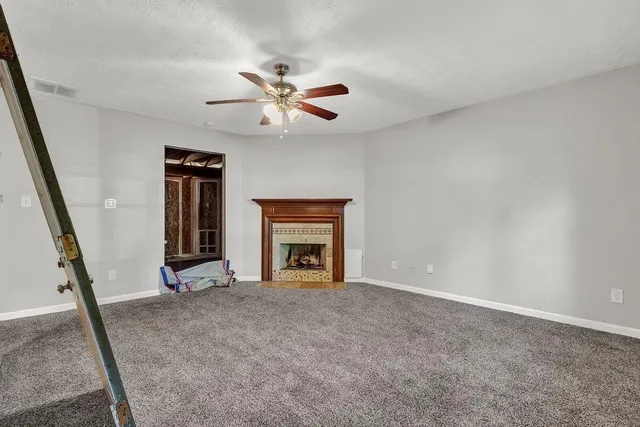 a view of an empty room with window and fireplace