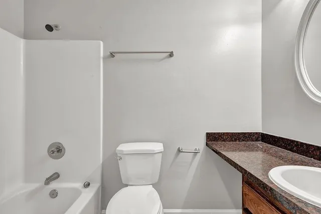 a bathroom with a granite countertop sink toilet and shower