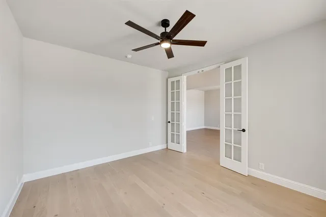 an empty room with closet and ceiling fan