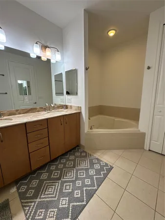a bathroom with a sink a large mirror and a bathtub