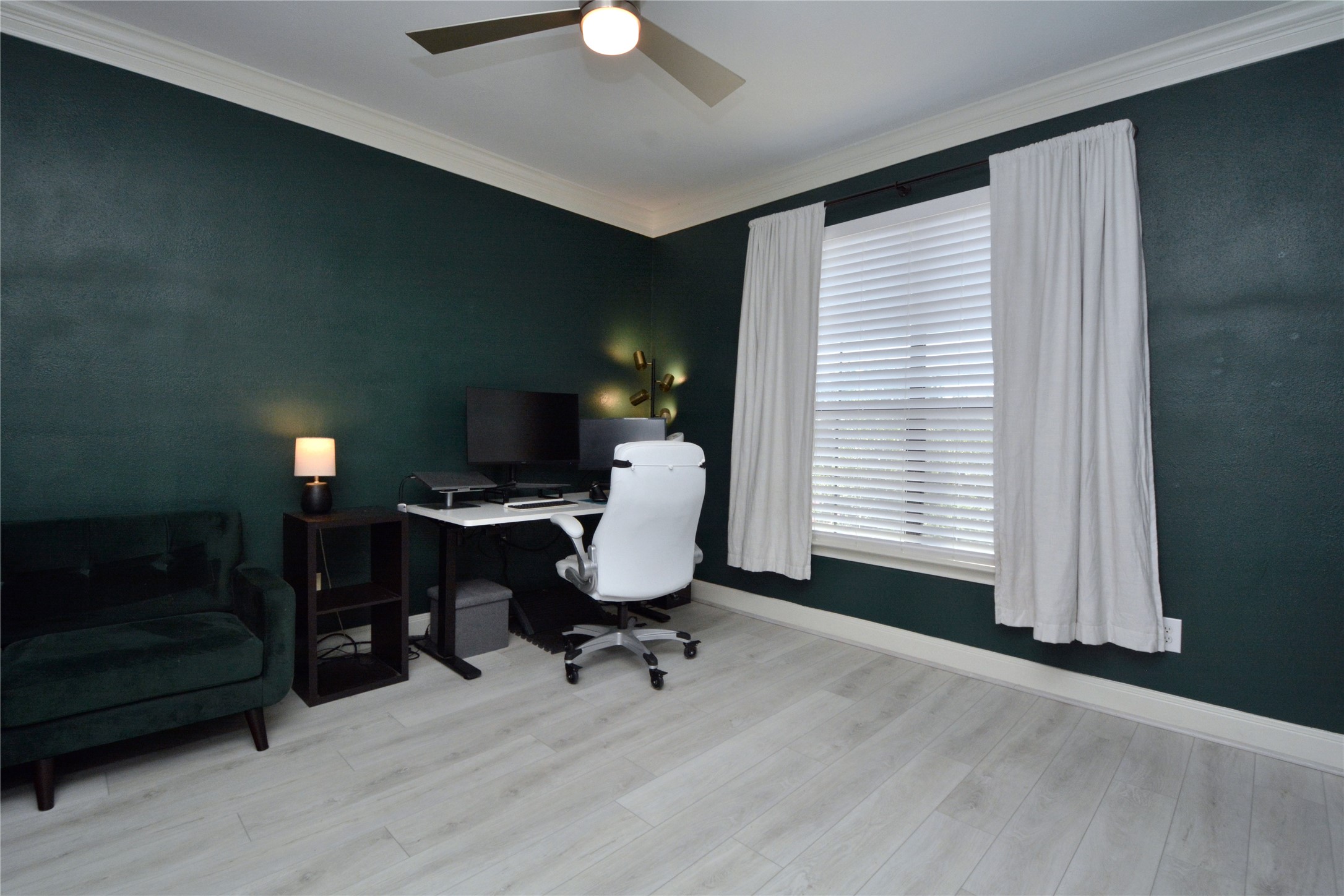 7701 Rialto Boulevard, Unit 124 Austin, TX 78735 - Photo 13 of 23 Room featuring a ceiling fan, crown molding, a window with blinds, and light wood-finish flooring