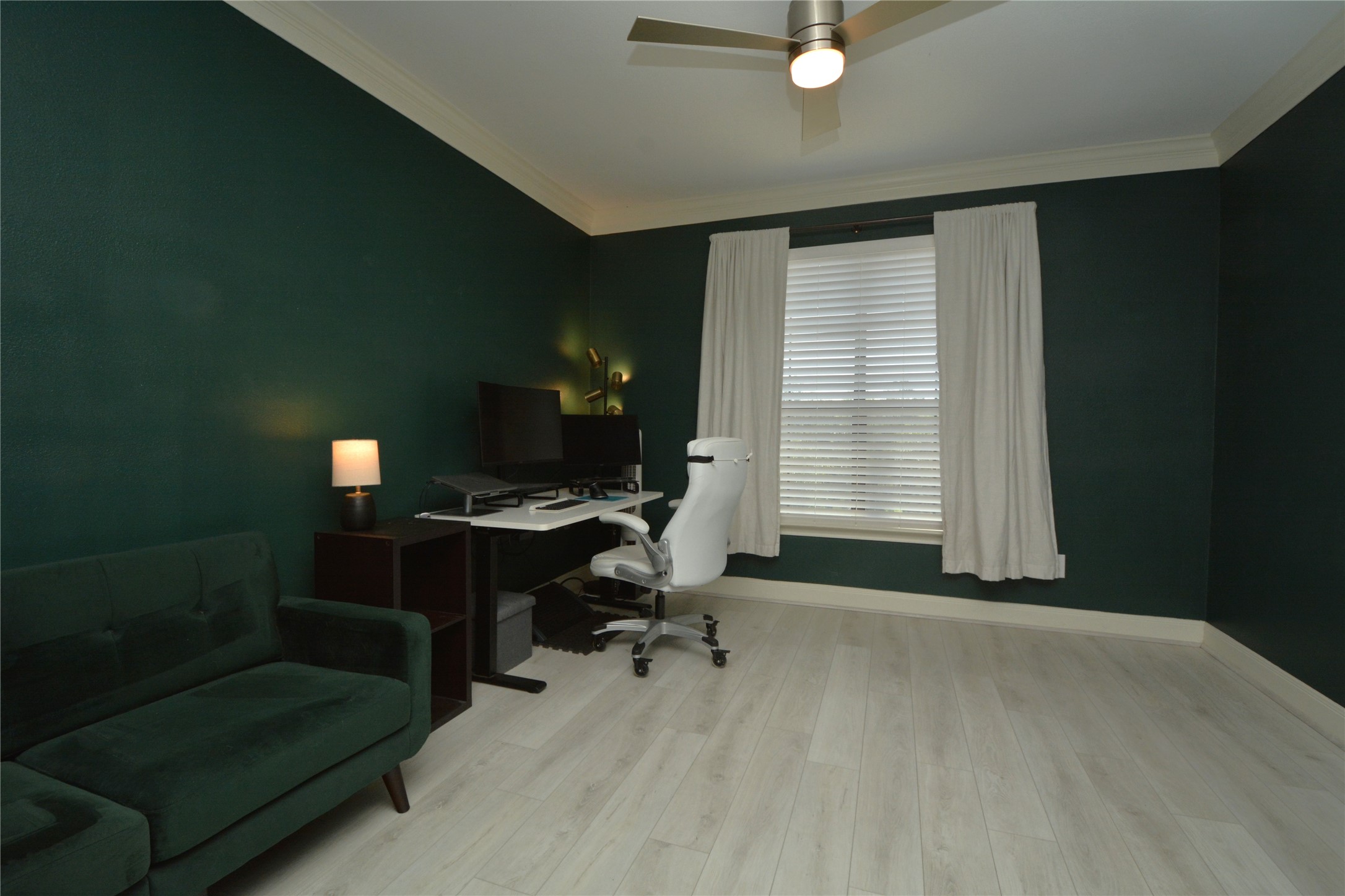 7701 Rialto Boulevard, Unit 124 Austin, TX 78735 - Photo 14 of 23 Spacious room featuring light wood-finish flooring, dark green walls, and white crown molding