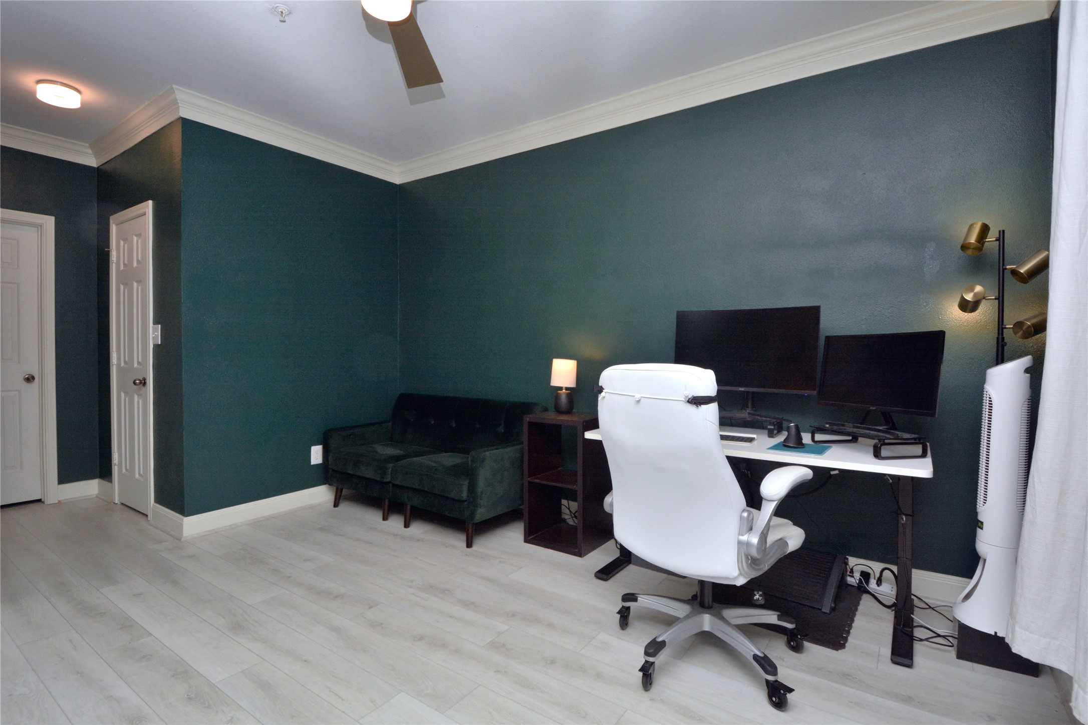 7701 Rialto Boulevard, Unit 124 Austin, TX 78735 - Photo 16 of 23 Room featuring light wood-finish flooring, dark teal walls, and white crown molding