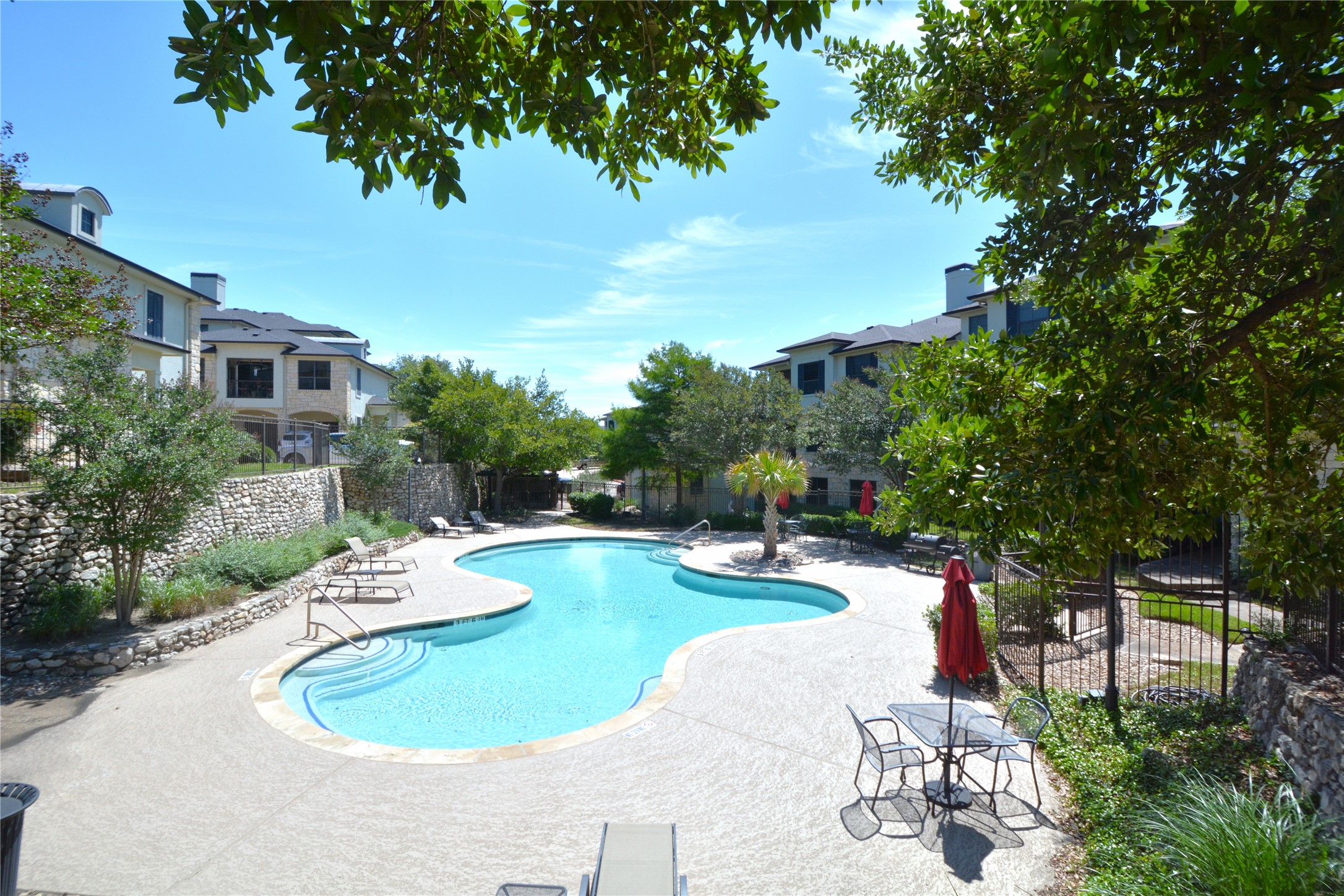 7701 Rialto Boulevard, Unit 124 Austin, TX 78735 - Photo 20 of 23 Resort-style swimming pool featuring a freeform design, integrated steps, and surrounding concrete decking