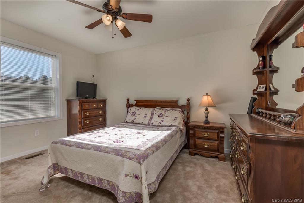 1632 Maple Creek Road Rutherfordton, NC 28139 - Photo 18 of 20 a bedroom with a bed and a chandelier