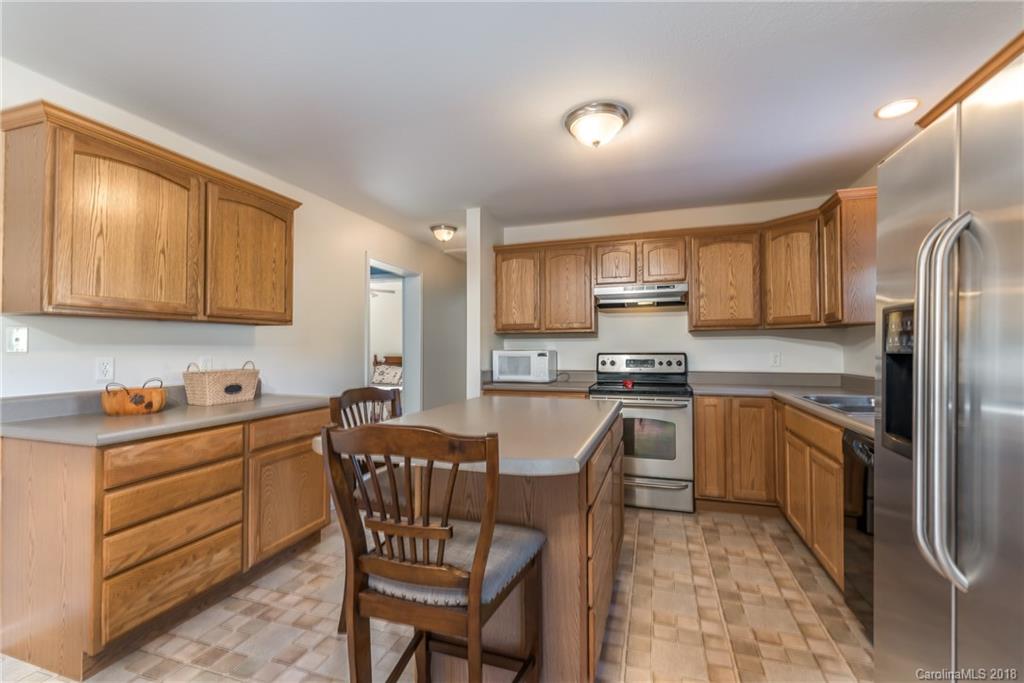 1632 Maple Creek Road Rutherfordton, NC 28139 - Photo 8 of 20 a kitchen with stainless steel appliances granite countertop a stove a sink dishwasher a refrigerator and cabinets with wooden floor