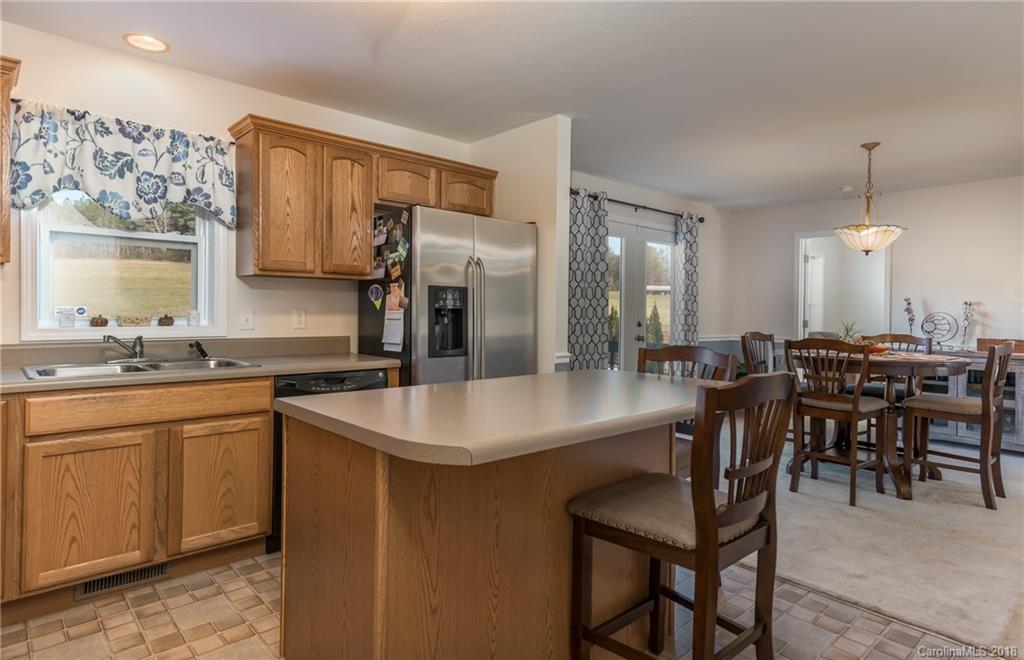 1632 Maple Creek Road Rutherfordton, NC 28139 - Photo 10 of 20 a kitchen with stainless steel appliances granite countertop a sink a stove a refrigerator a dining table and chairs