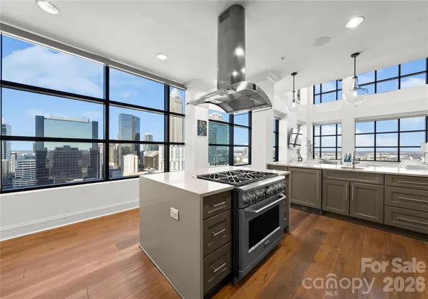 a kitchen with stainless steel appliances granite countertop a stove and a view of living room