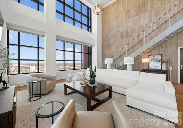 a living room with furniture a flat screen tv and a table