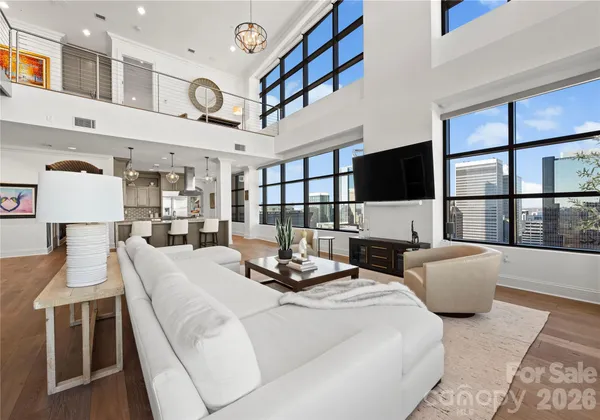 a living room with furniture a flat screen tv and a large window