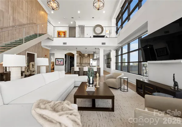 a view of living room kitchen with stainless steel appliances kitchen island granite countertop furniture and a view of living room
