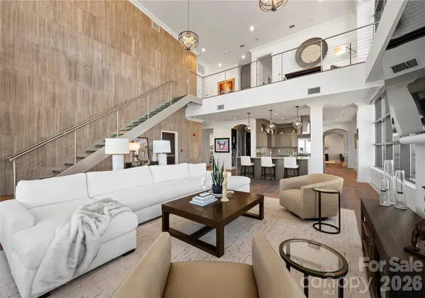 a living room with furniture white walls and kitchen view
