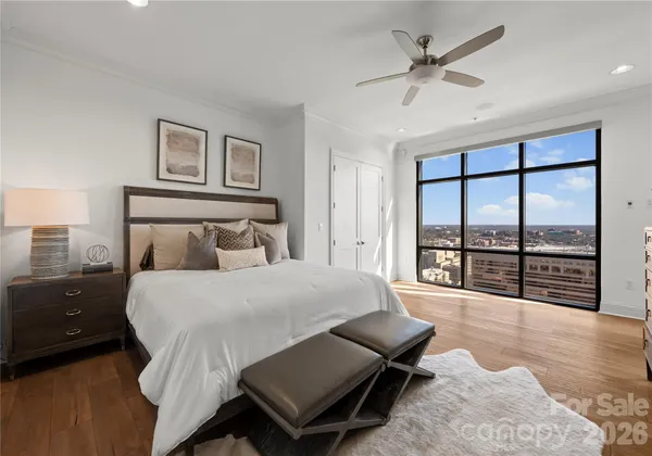 a spacious bedroom with a bed a couch and a large window