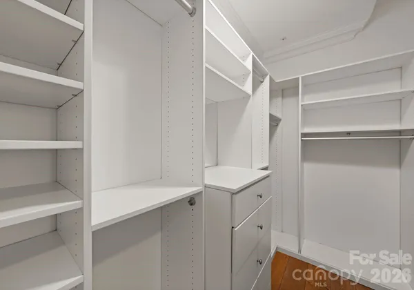 a view of walk in closet with empty racks