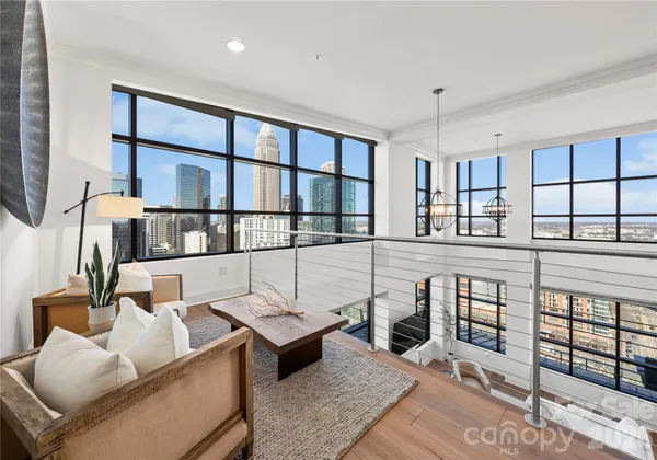 a living room with furniture a rug and a large window