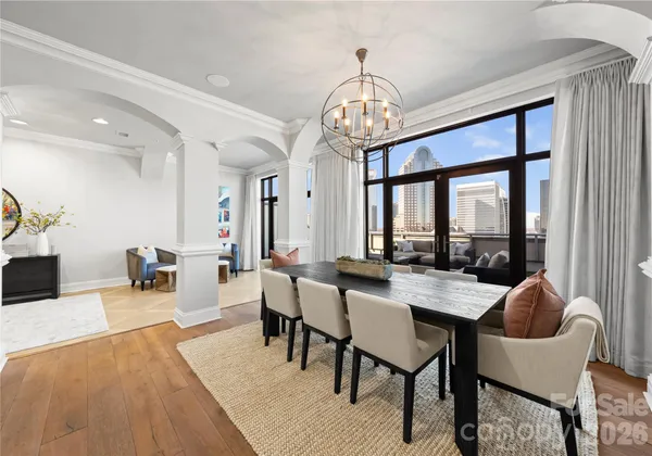a view of a dining room with furniture a chandelier and wooden floor