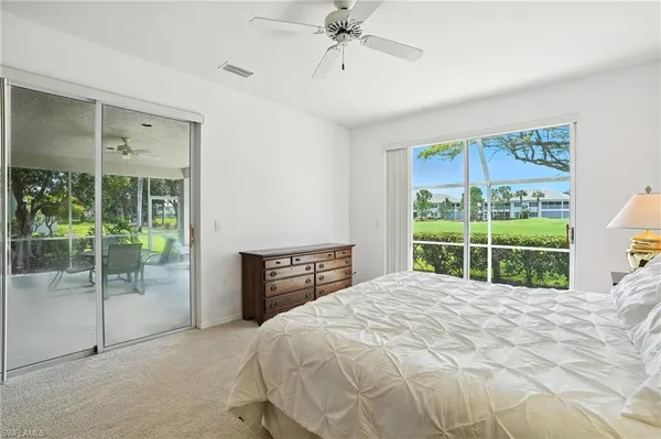 a bed sitting in a spacious bedroom next to a window