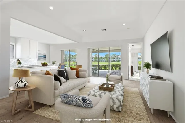 a living room with furniture wooden floor and a large window