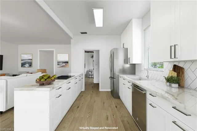 a large kitchen with a lot of counter space and wooden floor