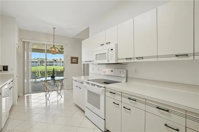 a kitchen with white cabinets and white appliances