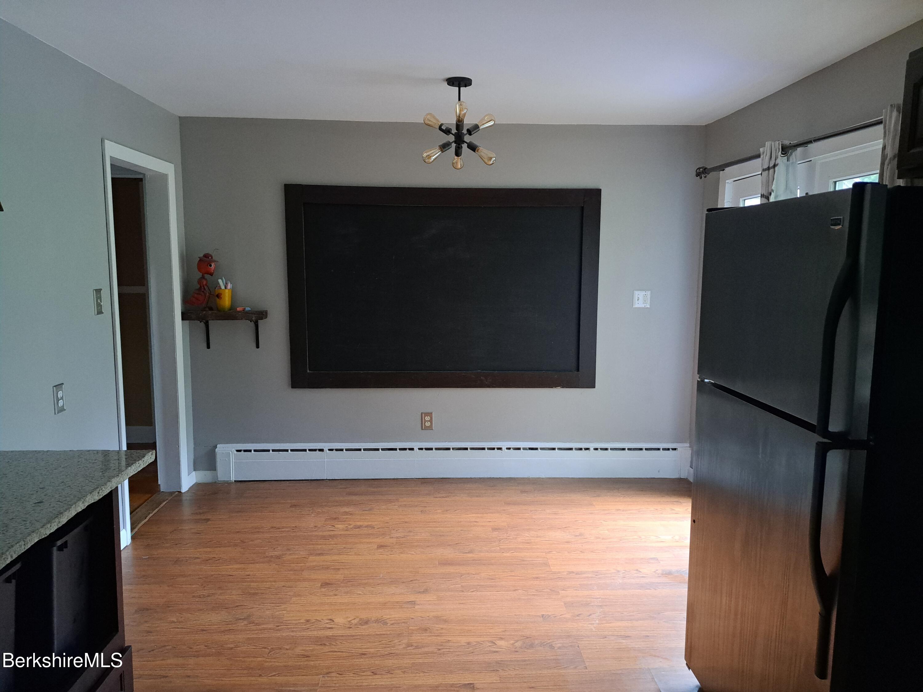 290 Lenox Avenue, Unit 1 Pittsfield, MA 01201 - Photo 4 of 8 a living room with a fireplace and a refrigerator